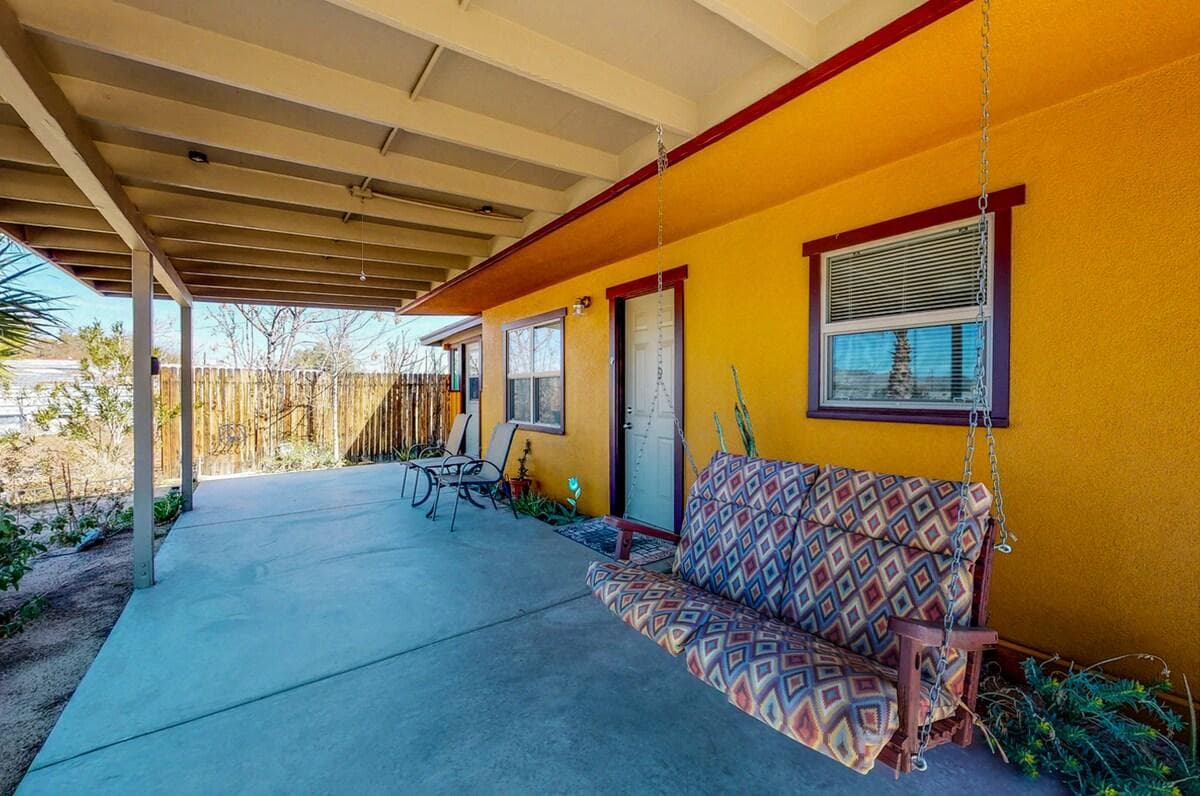 Covered patio with a cushioned bench along the bungalow