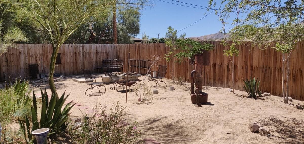 Fenced backyard with desert plants and a fire pit